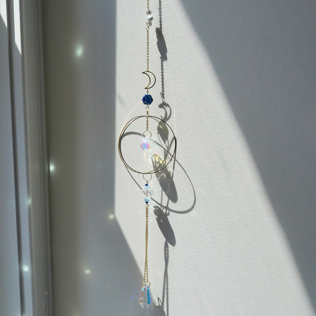 Decorative hanging chain with circular designs and beads on a light background